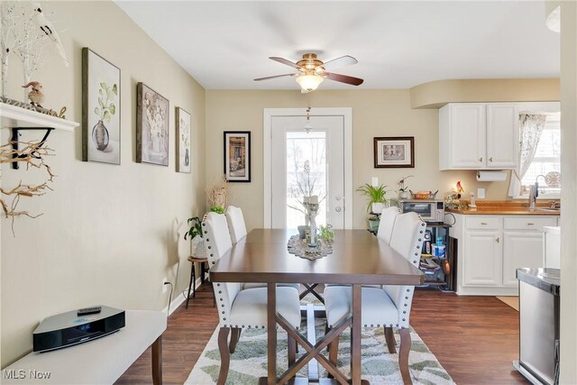 dining area featuring ceiling fan, a healthy amount of sunlight, dark wood finished floors, and a toaster