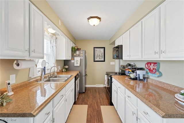 kitchen with a sink, dark wood-style floors, white cabinetry, stainless steel appliances, and baseboards