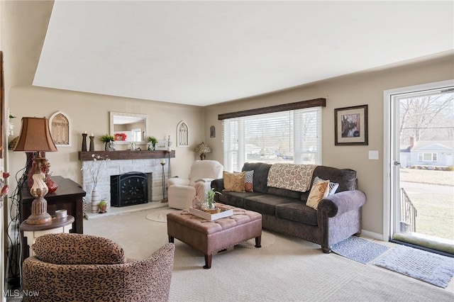 carpeted living room featuring a stone fireplace