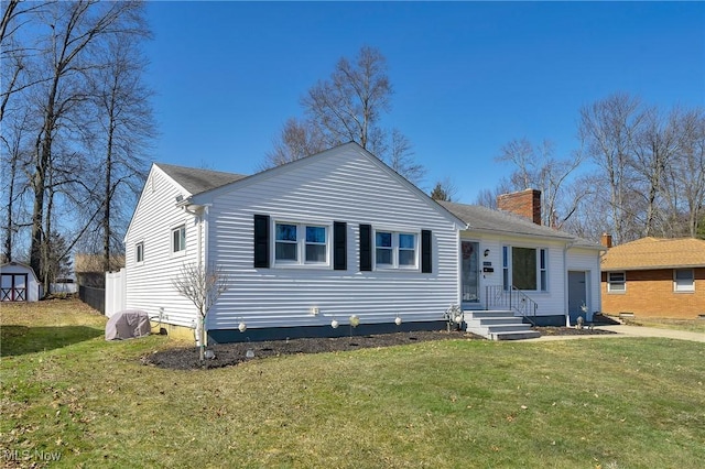 view of front of property with an outbuilding, a shed, a chimney, and a front yard