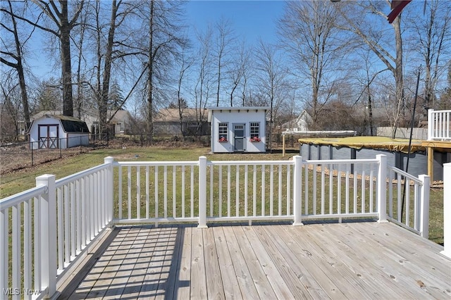 deck with an outbuilding, a storage shed, and a yard