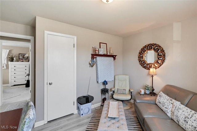 sitting room featuring baseboards and light wood-type flooring