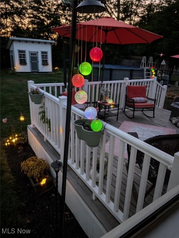 wooden deck featuring a lawn and an outdoor structure