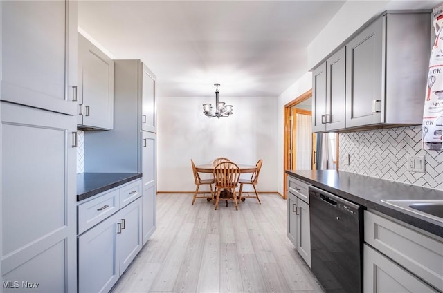 kitchen featuring light wood-style floors, tasteful backsplash, dark countertops, and dishwasher