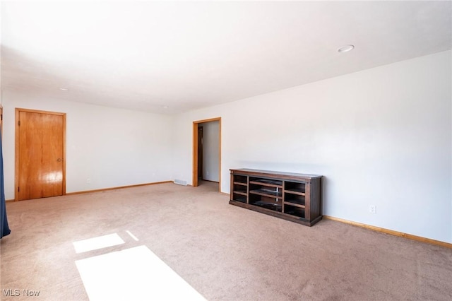 empty room featuring baseboards and carpet flooring