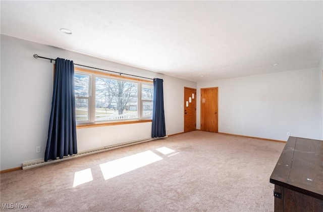 unfurnished living room with carpet flooring, baseboard heating, and baseboards