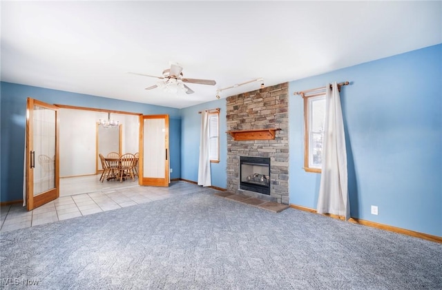 unfurnished living room featuring baseboards, carpet floors, a fireplace, tile patterned flooring, and rail lighting