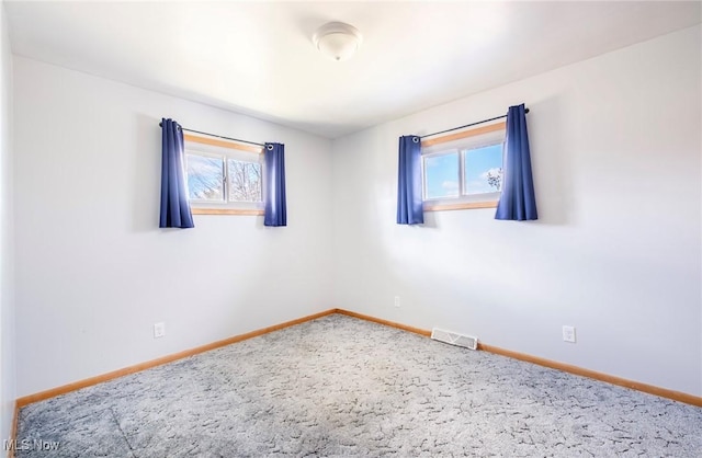 spare room with plenty of natural light, baseboards, and visible vents