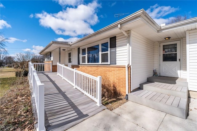 doorway to property with covered porch and brick siding