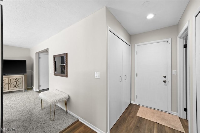 entrance foyer featuring dark wood finished floors, a textured ceiling, and baseboards