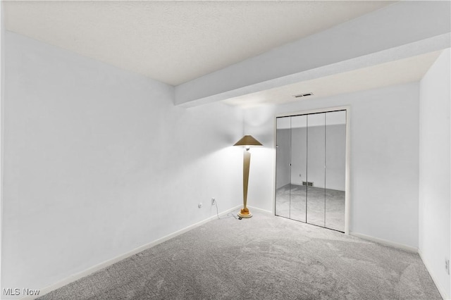 unfurnished bedroom with visible vents, baseboards, a closet, and carpet flooring