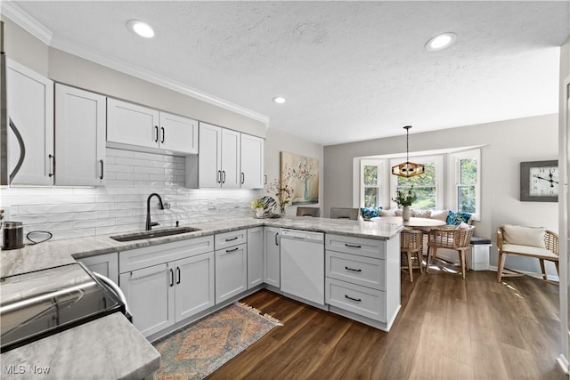 kitchen with a peninsula, white dishwasher, a sink, dark wood-type flooring, and backsplash