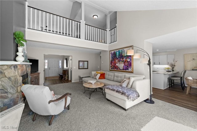 living room featuring a fireplace, wood finished floors, and high vaulted ceiling