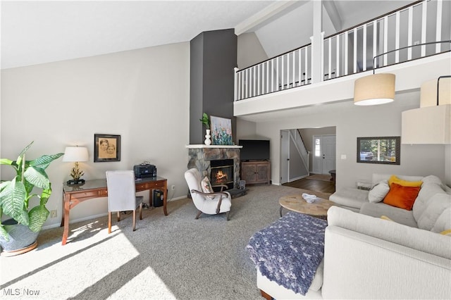 living area featuring baseboards, carpet floors, beam ceiling, a stone fireplace, and high vaulted ceiling