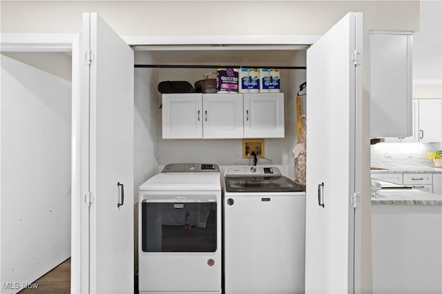 washroom with wood finished floors, cabinet space, and washing machine and clothes dryer