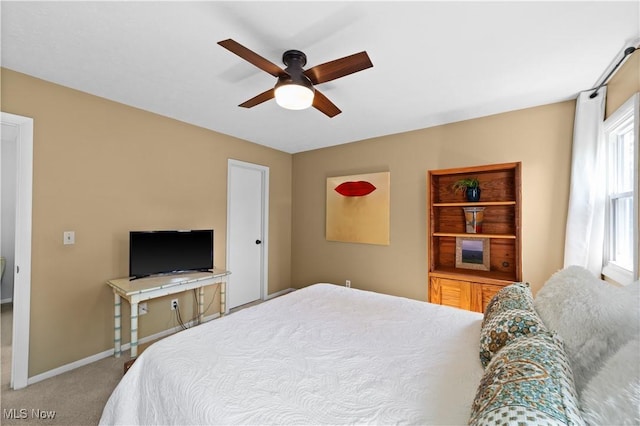 carpeted bedroom with a ceiling fan and baseboards