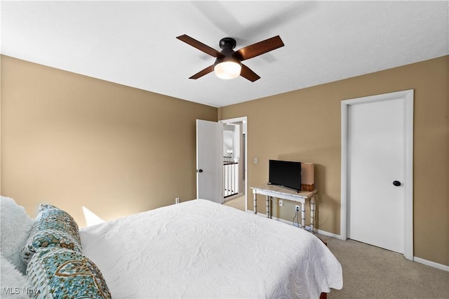 bedroom featuring baseboards, light colored carpet, and a ceiling fan