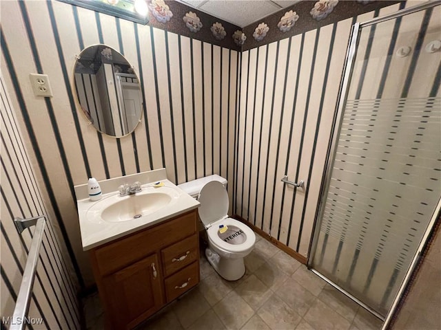 bathroom with a shower with door, toilet, wallpapered walls, and vanity