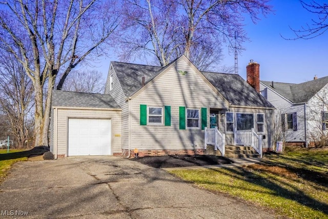 view of front of home featuring aphalt driveway, roof with shingles, a chimney, and an attached garage