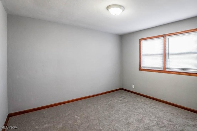 carpeted spare room with baseboards