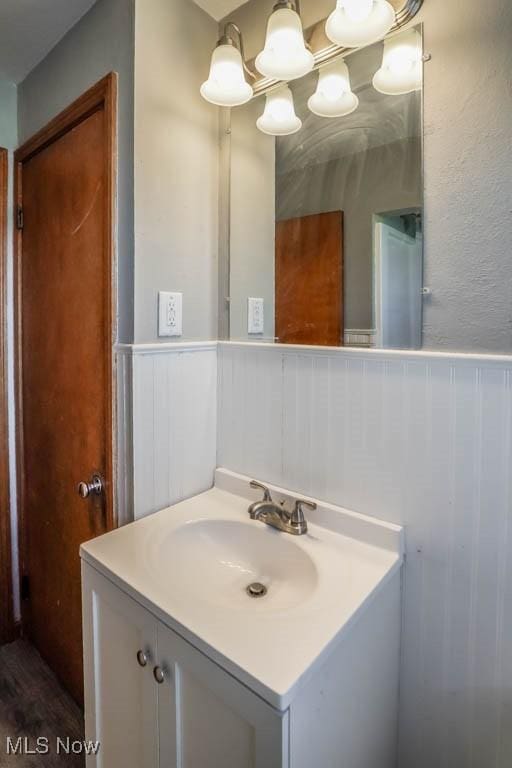 bathroom with vanity and a wainscoted wall