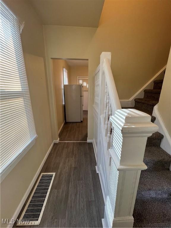 staircase featuring visible vents, baseboards, and wood finished floors