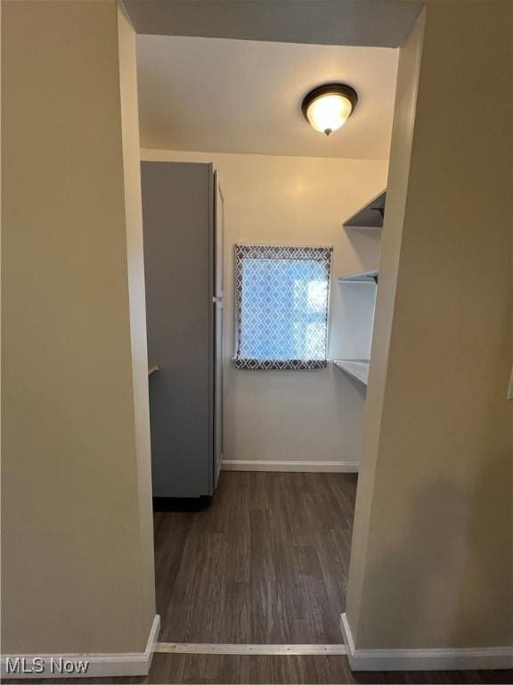 hallway with baseboards and wood finished floors