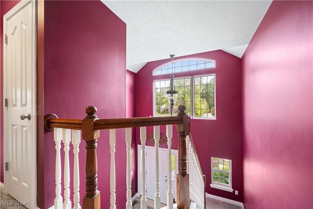 stairway with vaulted ceiling and a textured ceiling