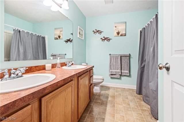 bathroom with double vanity, visible vents, toilet, and a sink