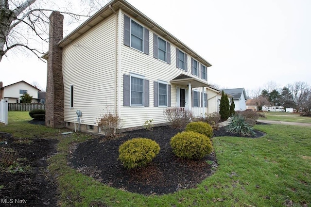 view of home's exterior with a lawn, fence, and a chimney