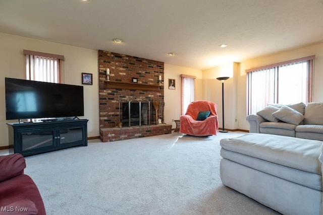 living room with a healthy amount of sunlight, a fireplace, baseboards, and carpet