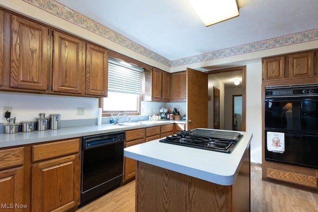 kitchen featuring black appliances, brown cabinetry, and light countertops