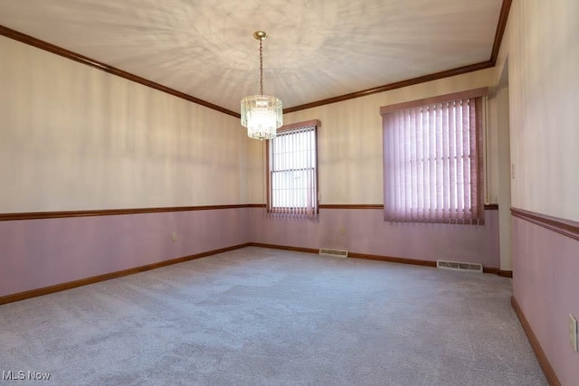 carpeted empty room featuring visible vents, baseboards, and ornamental molding