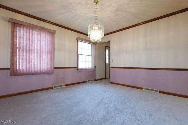 carpeted empty room with visible vents, baseboards, and ornamental molding