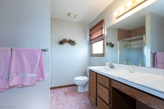 full bathroom featuring baseboards, vanity, a shower stall, and toilet