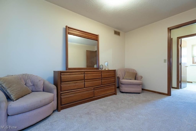 sitting room featuring visible vents, carpet flooring, a textured ceiling, and baseboards