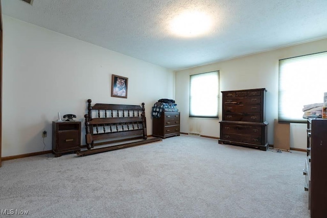 bedroom featuring carpet flooring, baseboards, and a textured ceiling