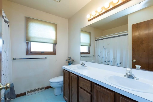 bathroom with plenty of natural light, toilet, visible vents, and a sink