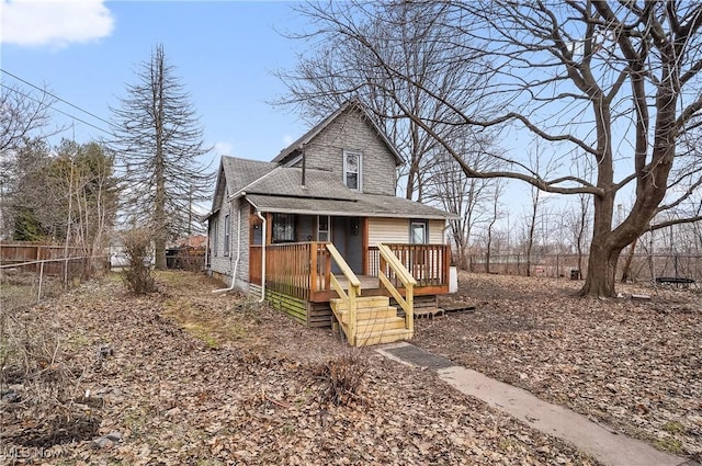 view of front of property featuring fence and roof with shingles