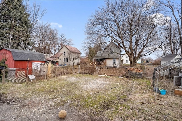 view of yard featuring a storage unit, an outdoor structure, and fence