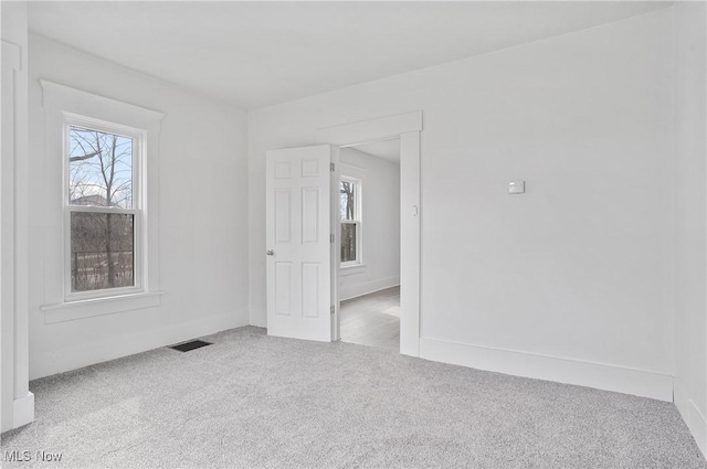 spare room featuring carpet flooring and visible vents