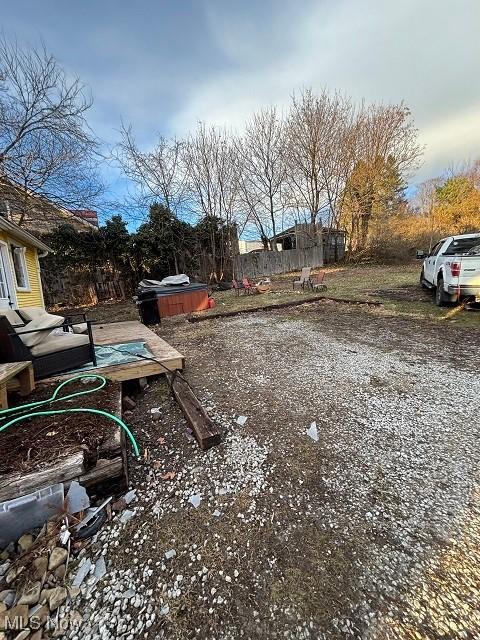 view of yard with a jacuzzi and fence