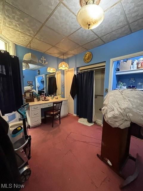 bedroom with a paneled ceiling and carpet