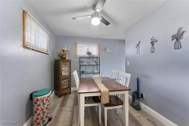 dining area with baseboards, light wood-style floors, and ceiling fan