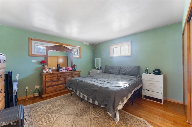 bedroom featuring baseboards and wood finished floors