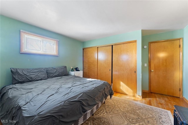 bedroom featuring baseboards, a closet, and light wood-type flooring