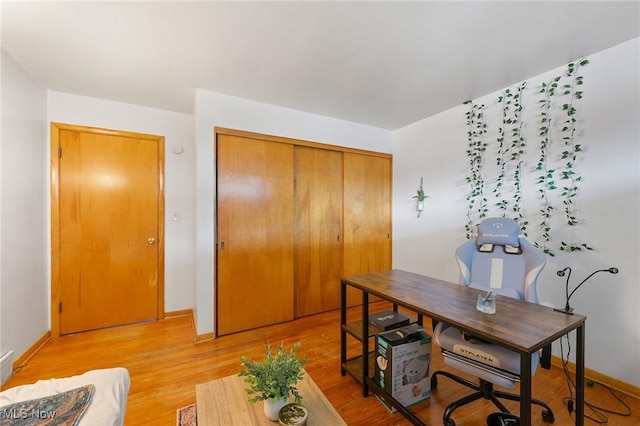 home office featuring light wood-type flooring and baseboards