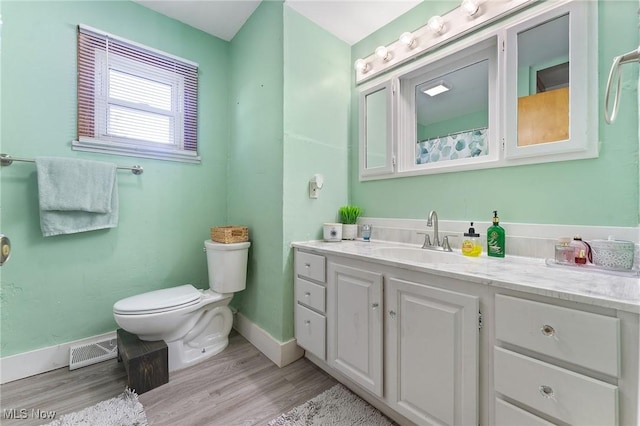 full bath featuring visible vents, toilet, wood finished floors, baseboards, and vanity