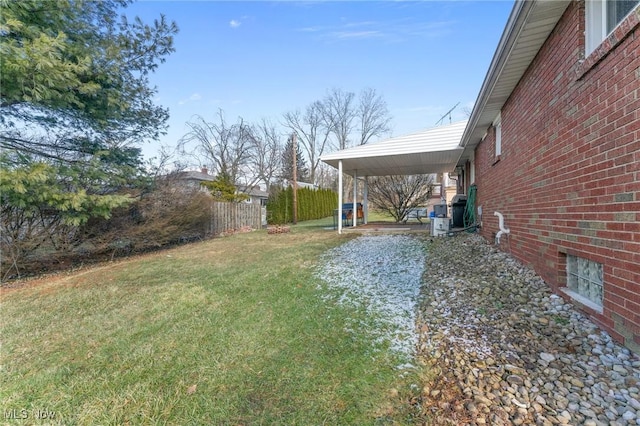 view of yard featuring an attached carport and fence