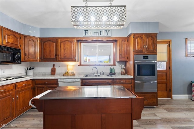 kitchen featuring a warming drawer, a sink, stovetop, white dishwasher, and black microwave